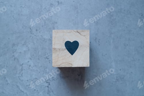 Preview: Health insurance concept. Wooden cube with a medical heart symbol on a gray background, copy space.