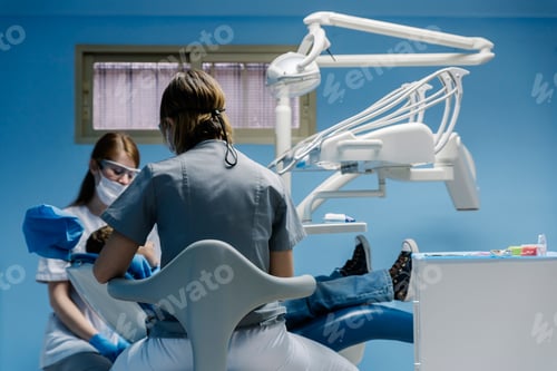 Preview: Dentists with a patient during a dental intervention to boy.