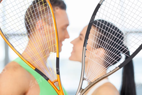Preview: Fitness couple. Loving couple kissing behind tennis racket