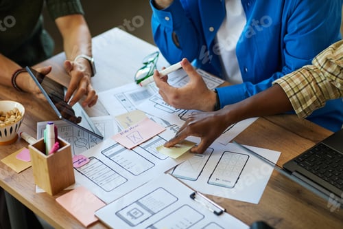 Preview: Diverse Young Adults Collaborating on Mobile App Design Project at Table