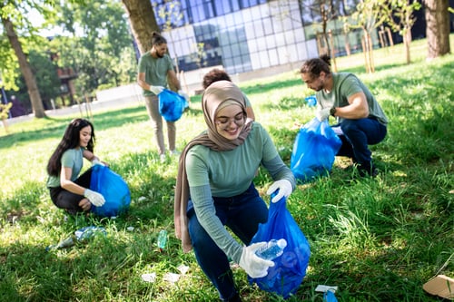 Preview: Multiethnic group of volunteers with garbage bags cleaning city park.