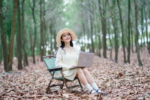 Preview: Woman With Laptop Relaxing Outdoors in Green Chair