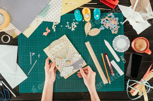 Preview: cropped image of artist holding scrapbooking handmade postcard with wooden balloon