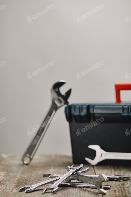 Preview: Close up of various tools on wooden table on grey background