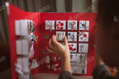 Preview: Pretty girl holds original advent calendar made of jewelry boxes and binder, Christmas diy craft