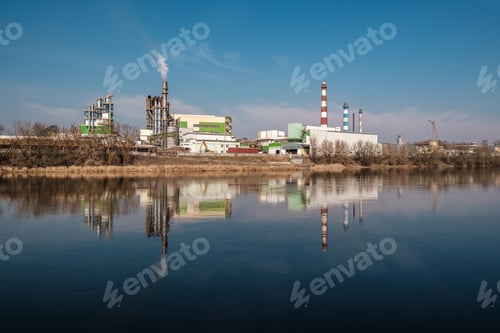 Preview: pipes of woodworking enterprise plant sawmill near river. Air pollution concept.