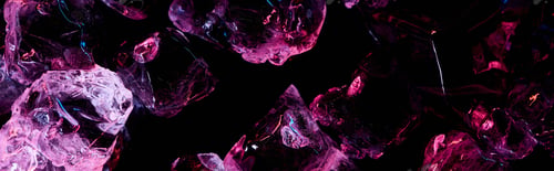 Preview: panoramic shot of transparent ice cubes with purple light isolated on black