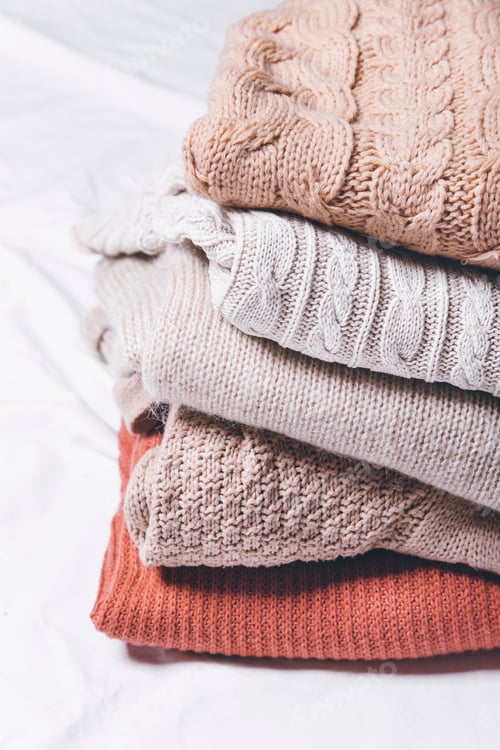 Preview: Stack of Cozy Knitted Sweaters on White