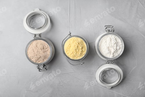 Preview: Jars with different types of flour on gray background