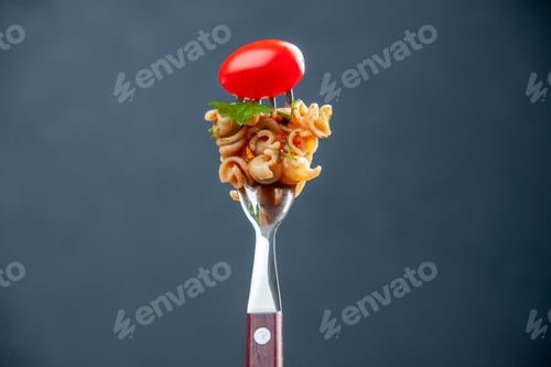 Preview: front view rotini pasta with cherry tomato on fork on grey isolated background with free space