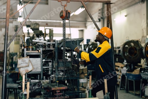 Preview: black african worker working in heavy metal industry factory hoist lifting heavy machine part