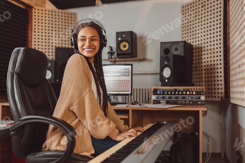 Preview: Attractive stylish African American female musician sound engineer playing synthesizer