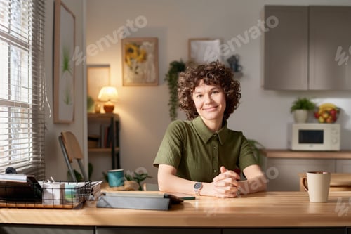 Preview: Young woman sitting in the kitchen