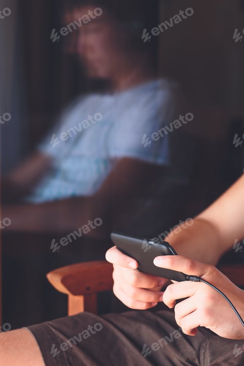 Preview: Man using technology. Reflection of young man using mobile phone texting listening to music online