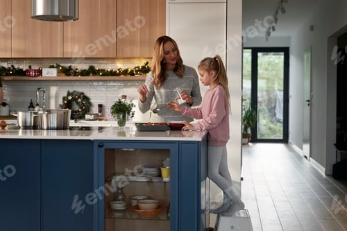 Preview: Caucasian daughter and mother preparing food before Christmas