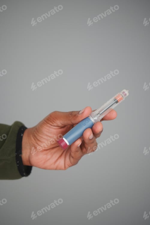 Preview: Hand holding a insulin against gray background