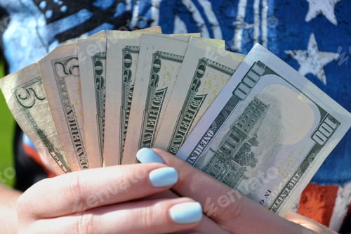 Preview: A female holds a handful of money, cash, currency, economy