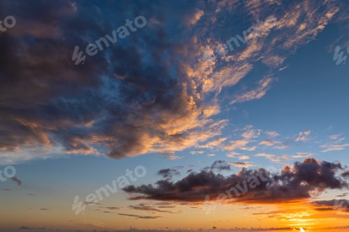 Preview: Colorful sunset sky with setting sun behind vivid orange and yellow clouds