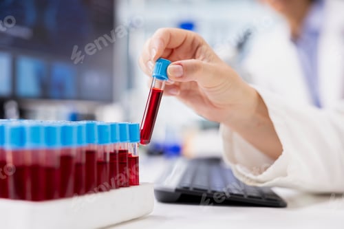 Preview: Close up of chemical engineer using laboratory glassware with red solution