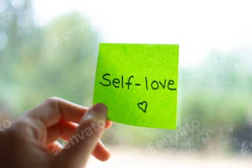 Preview: Hand holding green sticky note with self-love message promoting mental health awareness