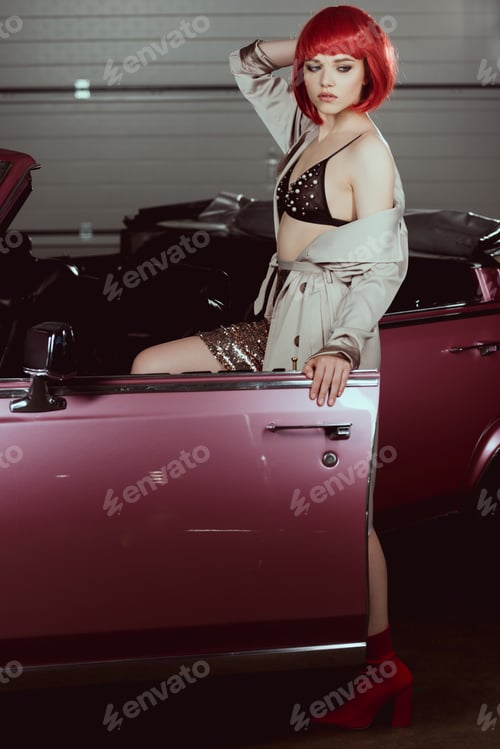 Preview: beautiful stylish girl opening vintage car and looking away