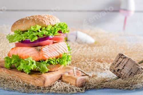 Preview: Delicious burger with fish and vegetables on old wooden table