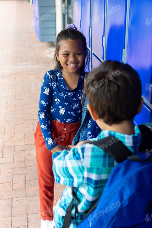 Preview: A biracial girl smiles at a biracial boy with his back to the camera