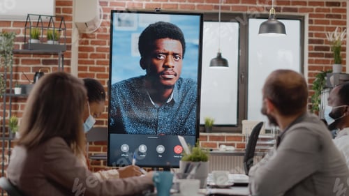 Preview: Diverse workmates talking to man on online video call conference