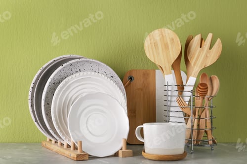 Preview: Set of kitchenware on marble table near green wall. Modern interior design