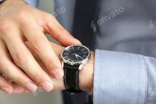 Preview: Man wearing luxury wrist watch with leather band, closeup