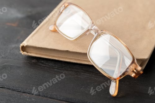 Preview: Close-up of eyeglasses on a book on table