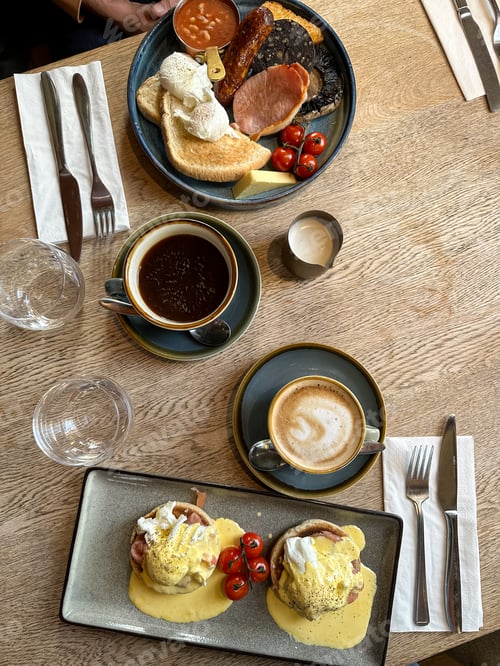 Preview: Breakfast for two on a wooden table in a cafe. Full English breakfast and eggs royal