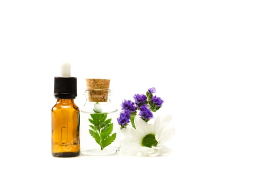 Preview: bottles with liquid near limonium and chrysanthemum flowers isolated on white