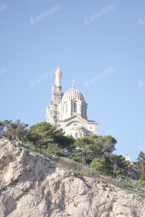 Preview: Low-angle shot the cathedral of Notre dame de lagarde in Marseille, France atop a rocky outcrop
