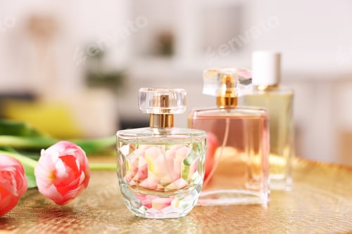 Vista previa: Bottles of aromatic perfume and flowers on textured plate against blurred background, closeup