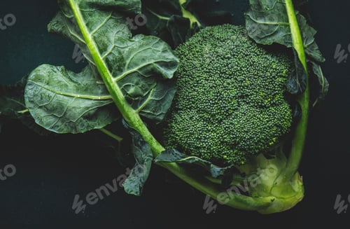 Preview: Fresh organic broccoli cabbage with leaves on old rustic green kitchen table background, top view