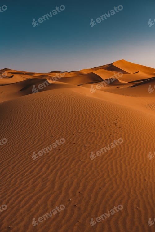 Preview: Vertical shot of a peaceful desert under the clear blue sky captured in Morocco