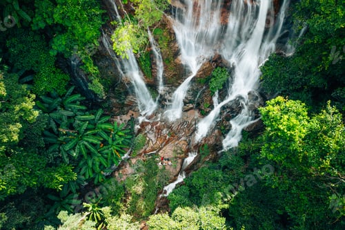Preview: Aerial view of a beautiful waterfall in the middle of a forest in the pristine nature of the forest.