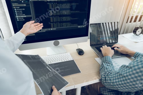Preview: Two software developers are analyzing together about the code written into the program