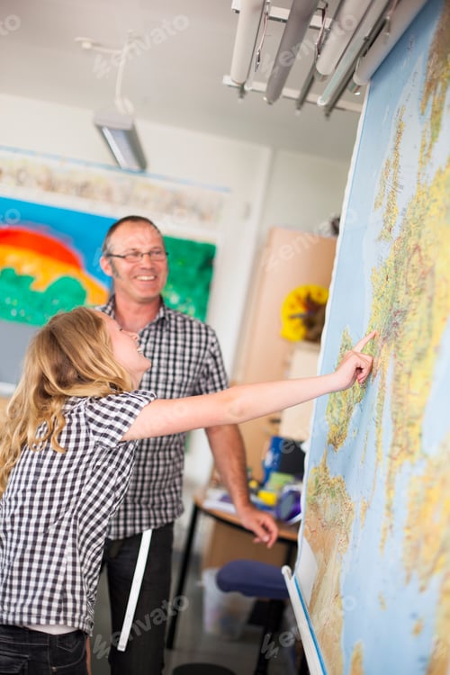 Preview: Happy male teacher assisting junior high student in classroom