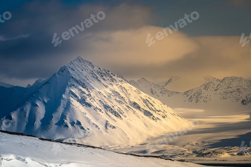 Preview: A snow-covered peak and valley with nice smooth clouds in the arctic