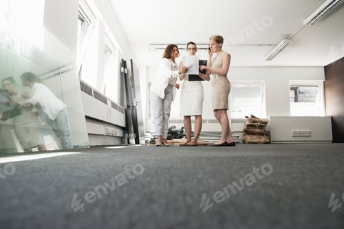 Preview: Three young businesswomen chatting in new office