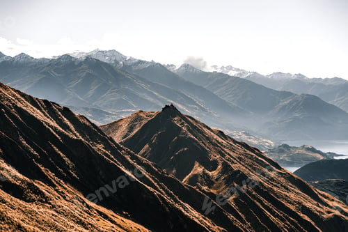 Preview: landscape with many mountains with greenery around on the shore of the big blue lake between rocky