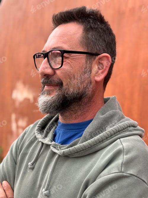 Preview: Portrait of adult man smiling and looking in front wearing glasses and green sweater