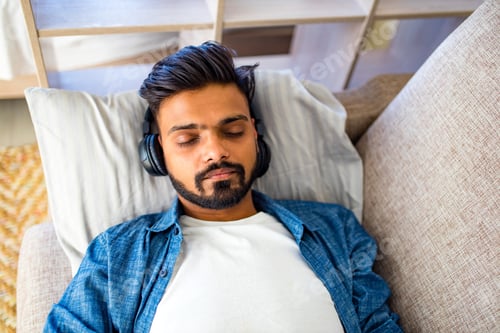 Preview: bearded arabian man listening audio meditation business training personal growth in new apartment