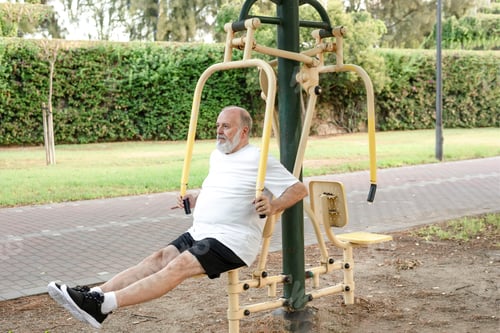 Preview: A senior man exercises on the public gym equipment in the open air