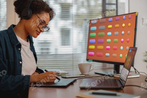Preview: Woman designer works in home office drawing on graphic tablet. Freelancer working on project