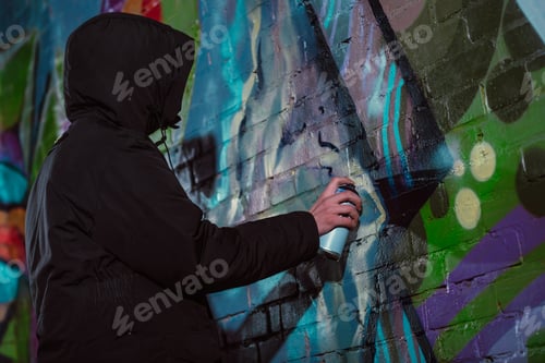 Visualização: grafite de pintura anônima com tinta aerossol na parede à noite