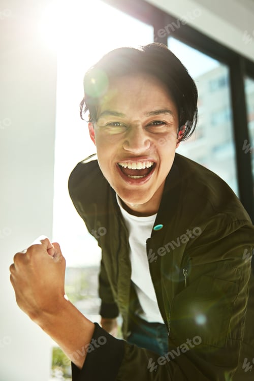 Preview: Portrait of a happy young businessman celebrating a victory alone in the office