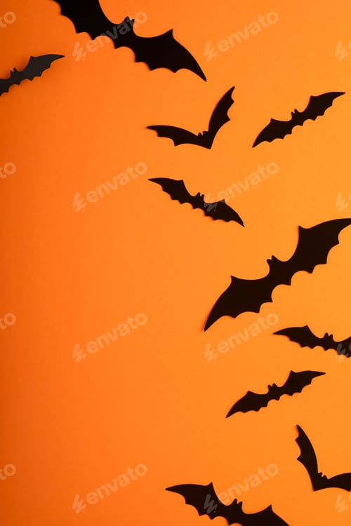 Preview: Orange Halloween background. Flock of black bats for Halloween. Black paper bat silhouettes on orang